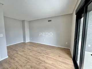 Ambiente interno de uma sala com piso de madeira clara.