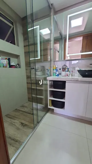 Vista de um interior com divisórias de vidro e acabamentos modernos.