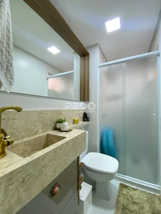 Foto de um banheiro moderno com bancada de mármore e box de vidro.