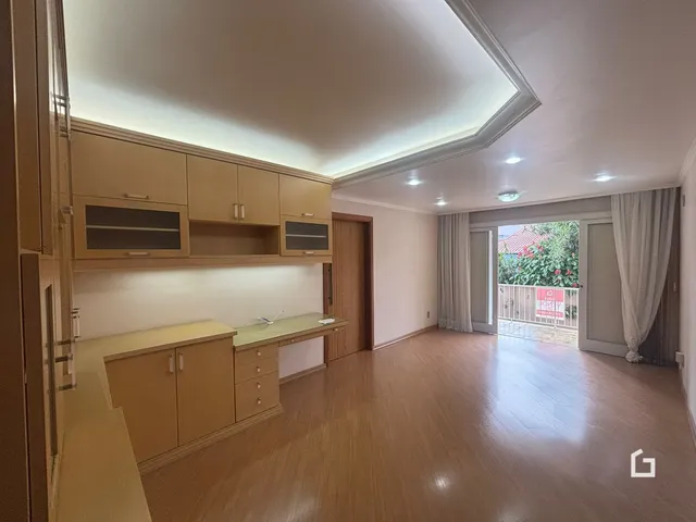 Sala de estar com piso de madeira e armários em um imóvel no Brasil.