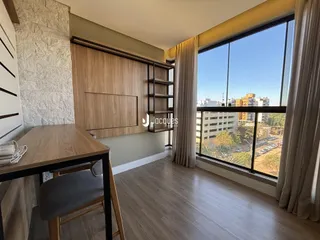Uma sala de estar com piso de madeira e grande janela.