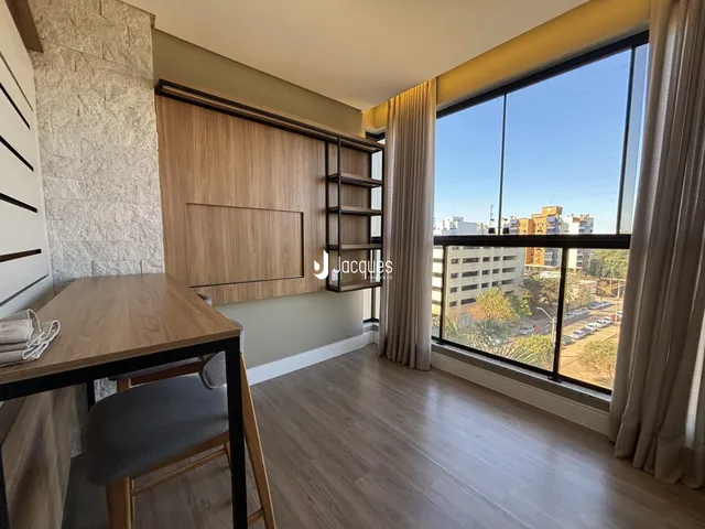 Uma sala de estar com piso de madeira e grande janela.