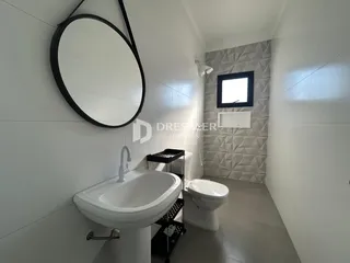 Banheiro com pia e vaso sanitário em ambiente interno.