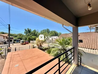 Vista da varanda com vegetação e céu azul.