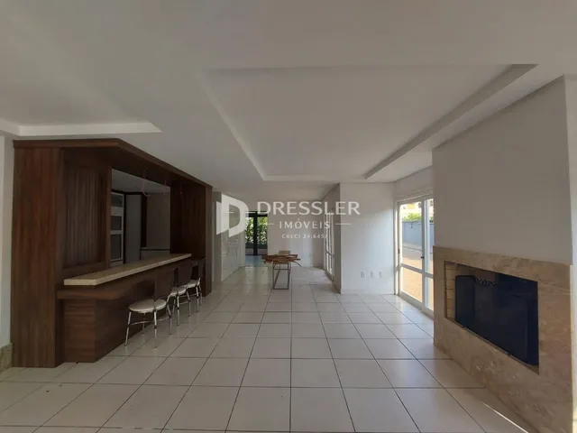 Sala de estar com piso de cerâmica e parede de lareira em um imóvel no Brasil.