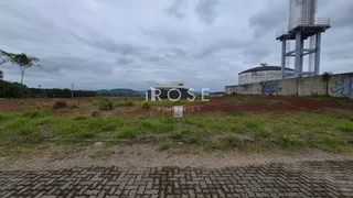 Vista externa de uma propriedade com terreno e muro de concreto.