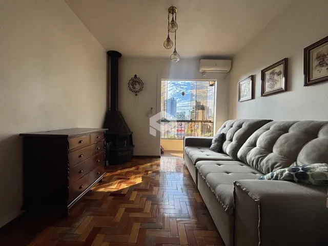 Sala de estar com piso de madeira e lareira em um imóvel no Brasil.