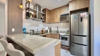 Cozinha moderna com armários de madeira e eletrodomésticos de aço inoxidável.
