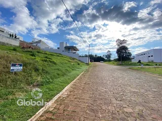 Uma estrada de paralelepípedos corre ao lado de uma colina gramada.