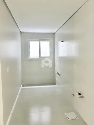 Corredor interno de uma residência com paredes brancas e piso claro.