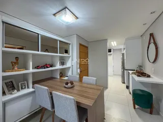 Foto de uma sala de jantar com mesa de madeira e estantes em um imóvel no Brasil.