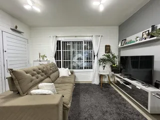 Sala de estar com sofá e janela em um imóvel no Brasil.