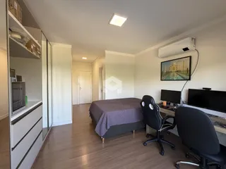 Quarto com cama e escrivaninha em um apartamento.