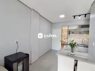 Vista de uma cozinha moderna com armários de vidro e bancada clara.