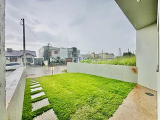 Jardim gramado com caminho de concreto em uma propriedade.