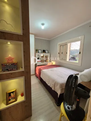 Quarto com cabeceira e estante em madeira.