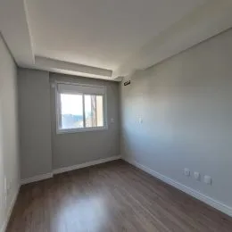 Foto de um ambiente interno com piso de madeira e janela.
