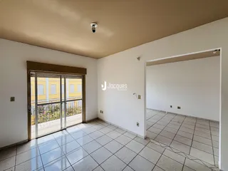 Interior de uma sala com piso de cerâmica e porta de vidro que dá para o exterior.