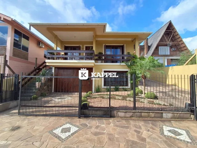Fachada de uma residência em Lajeado, Brasil, com cerca e paisagismo.
