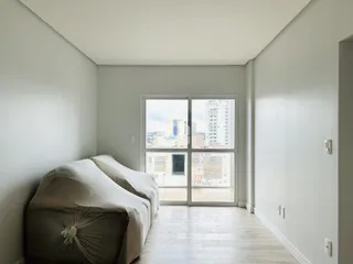 Um quarto com cama e porta de vidro voltada para a vista.