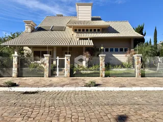 Fachada de uma residência em Lajeado, Brasil, com muro e portão de ferro.