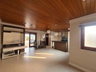 Interior de uma sala de estar com piso de cerâmica e teto de madeira.