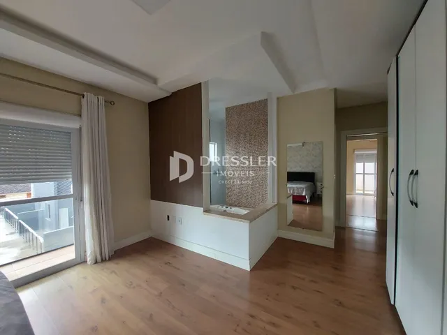 Sala de estar com piso de madeira e porta de vidro que dá para a varanda.