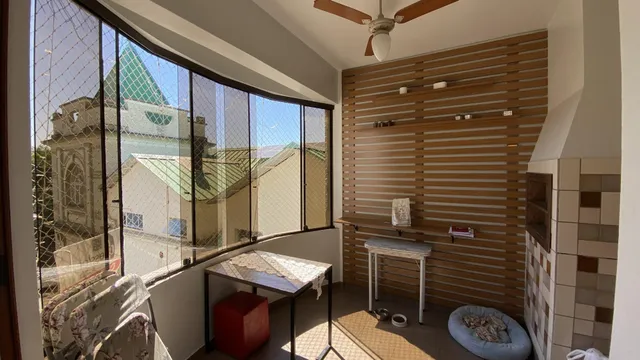 Vista da sala de estar com grandes janelas que oferecem uma vista externa.