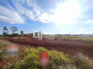 Paisagem de terra marrom com vegetação rasteira sob um céu azul claro.