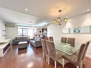 Sala de estar e jantar com piso de madeira e móveis modernos.
