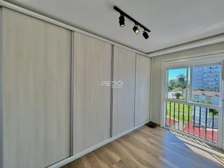 Interior de um cômodo com painéis de armário e piso de madeira clara.