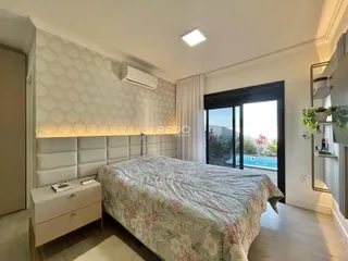 Quarto com cama e porta de vidro abrindo para o exterior.