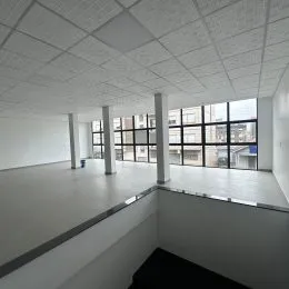 Foto de um espaço interno com teto de grid branco e paredes brancas.