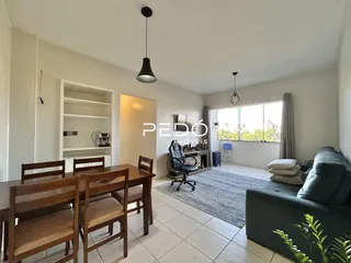 Sala de estar iluminada com sofá e janela em uma residência.