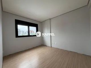 Sala de estar com piso de madeira e janela com vista para a paisagem urbana.
