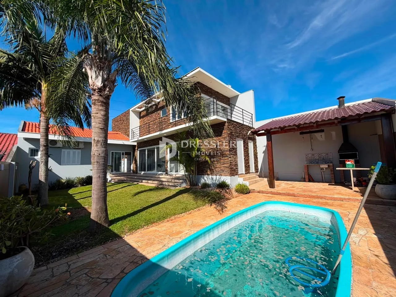 Fachada de casa com piscina e jardim em Lajeado, Brasil.