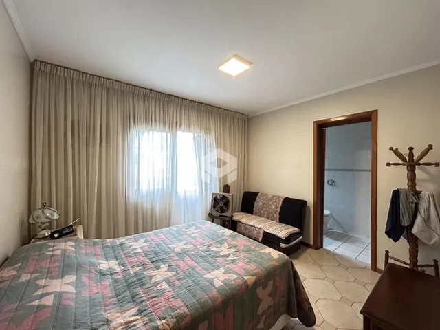 Quarto com janela e cortinas claras.