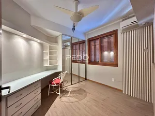 Sala de estar com piso de madeira e janelas de madeira.
