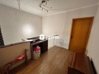 Foto interna de uma cozinha com piso de madeira e armários.