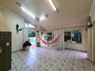 Sala de estar ampla com piso de cerâmica e vista para o jardim.