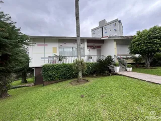 Fachada de um imóvel residencial com jardim frontal e varanda em Lajeado.