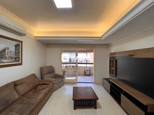 Foto de uma sala de estar com sofá e mesa de centro em um apartamento.