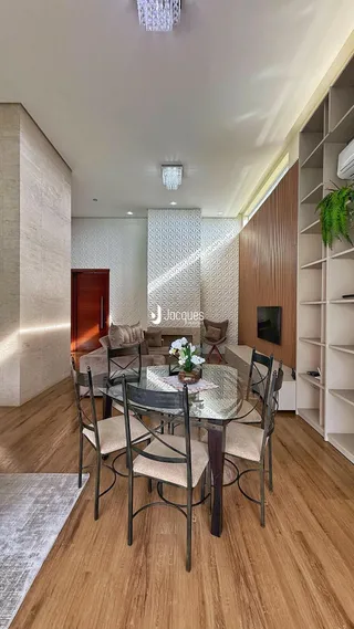Sala de jantar com piso de madeira e conjunto de mesa e cadeiras.