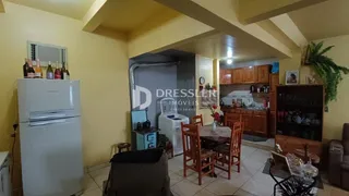 A sala de estar exibe uma cozinha e um refrigerador branco.