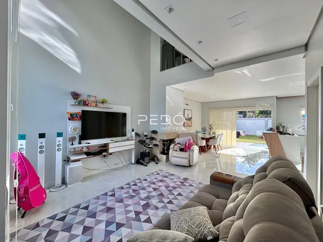 Sala de estar ampla com sofá e piso de cerâmica em imóvel no Brasil.
