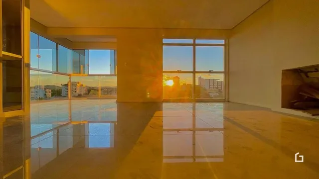 Ambiente interno com grandes janelas refletindo a luz do sol.