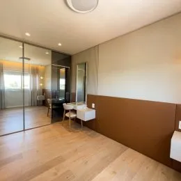 Ambiente interno com piso de madeira clara e paredes claras.
