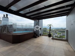 Vista da área externa com piscina e paisagem.