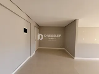 Foto do interior de um ambiente com paredes claras e piso de porcelanato.