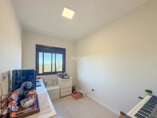 Ambiente interno de uma sala com janela e vista para a paisagem.